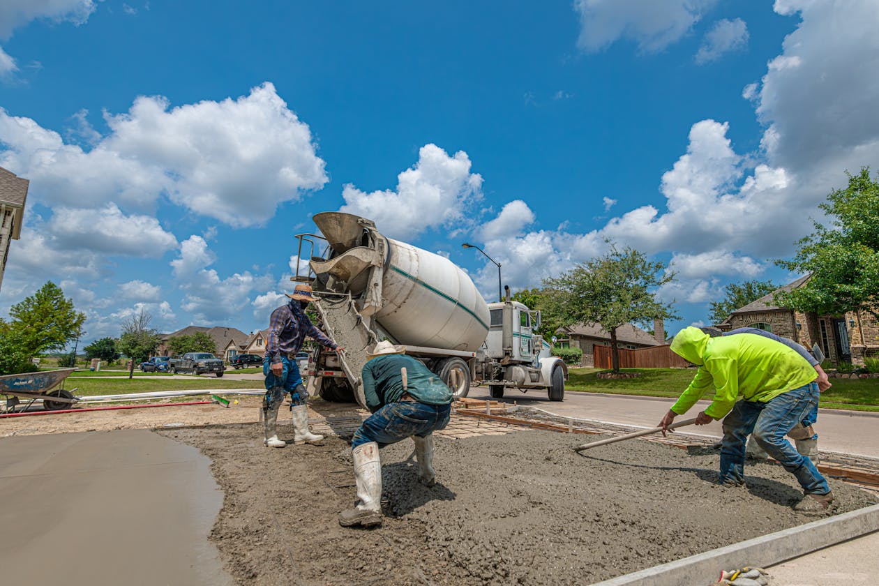 Workers pouring a fresh concrete driveway at a residential property